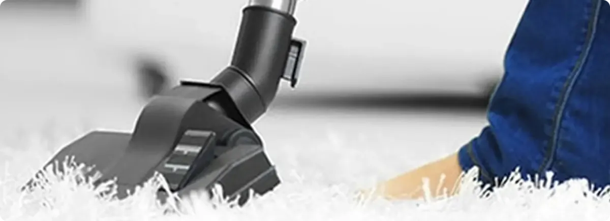 Close-up of a professional vacuuming a white carpet in Sullivans Island.